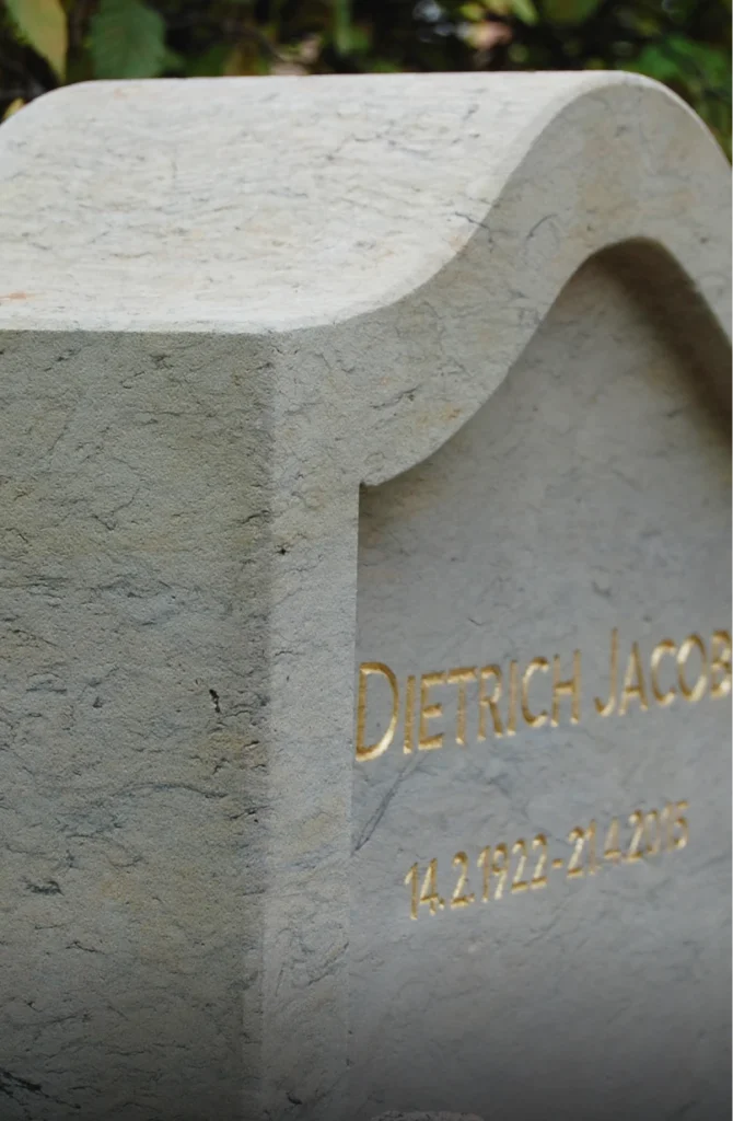Detail eines Grabsteins mit vergoldetem Schriftzug