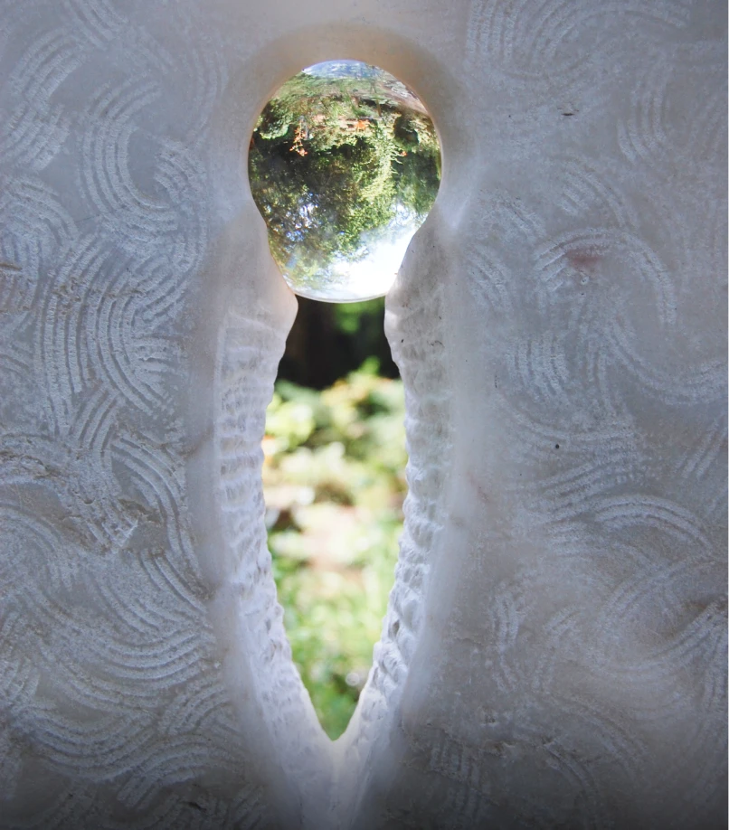 Durchbruch im Grabstein mit Glaskugel, in der die Umgebung auf dem Kopf steht, Grabmal von Michael Spengler