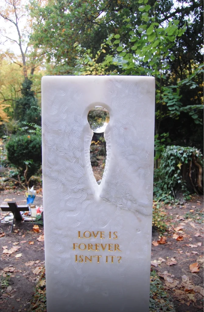 Rückseite des Grabmals mit dem Schriftzug „LOVE IS FOREVER ISN’T IT“ von Michael Spengler