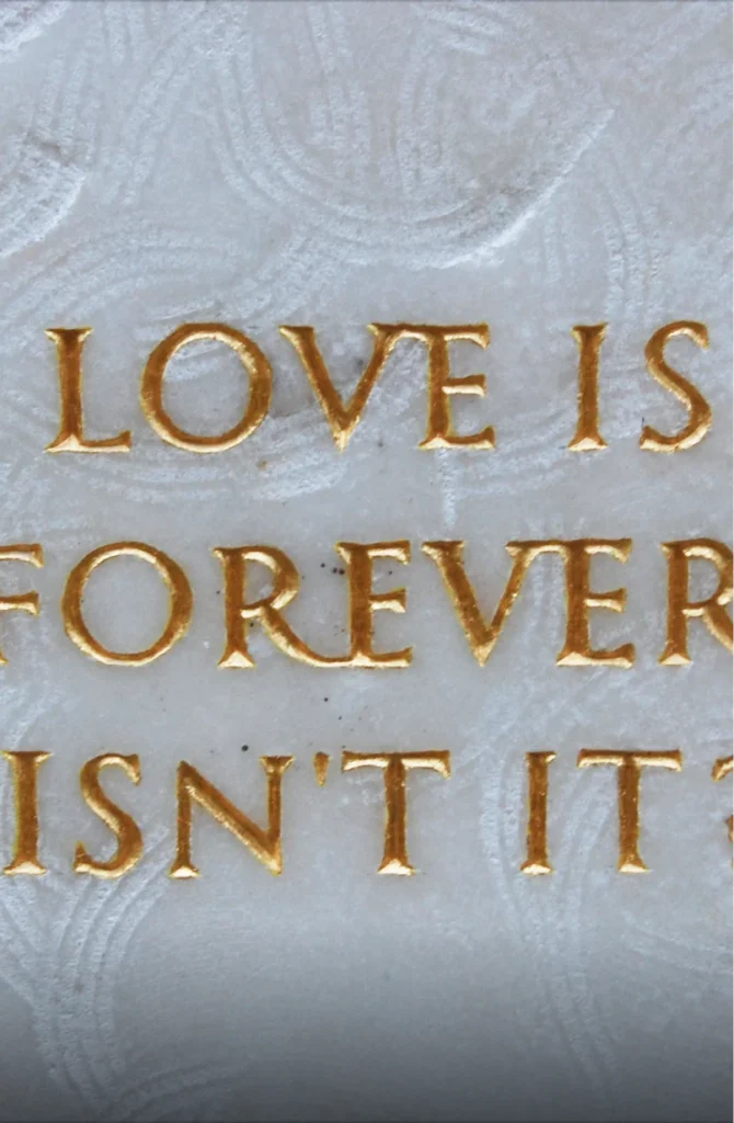 Detailaufnahme des vergoldeten Schriftzugs „LOVE IS FOREVER ISN’T IT“ im Grabmal von Michael Spengler