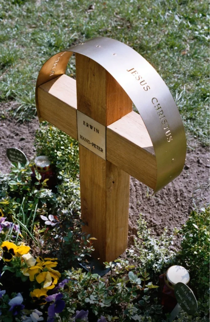 Grabstein mit Kreuz und Inschrift aus rechter Perspektive