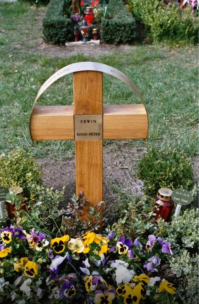 Grabstein mit Kreuz und schützendem Messingbogen mit Inschrift