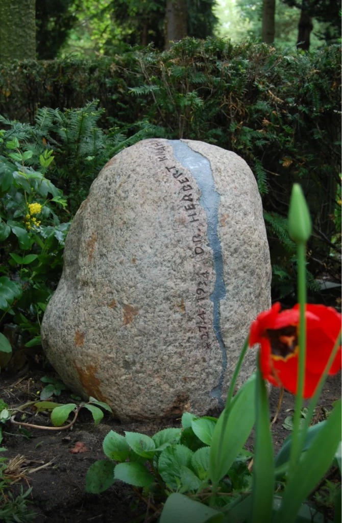 Grabstein auf einem Friedhof mit sichtbarem Bruch in natürlicher Umgebung