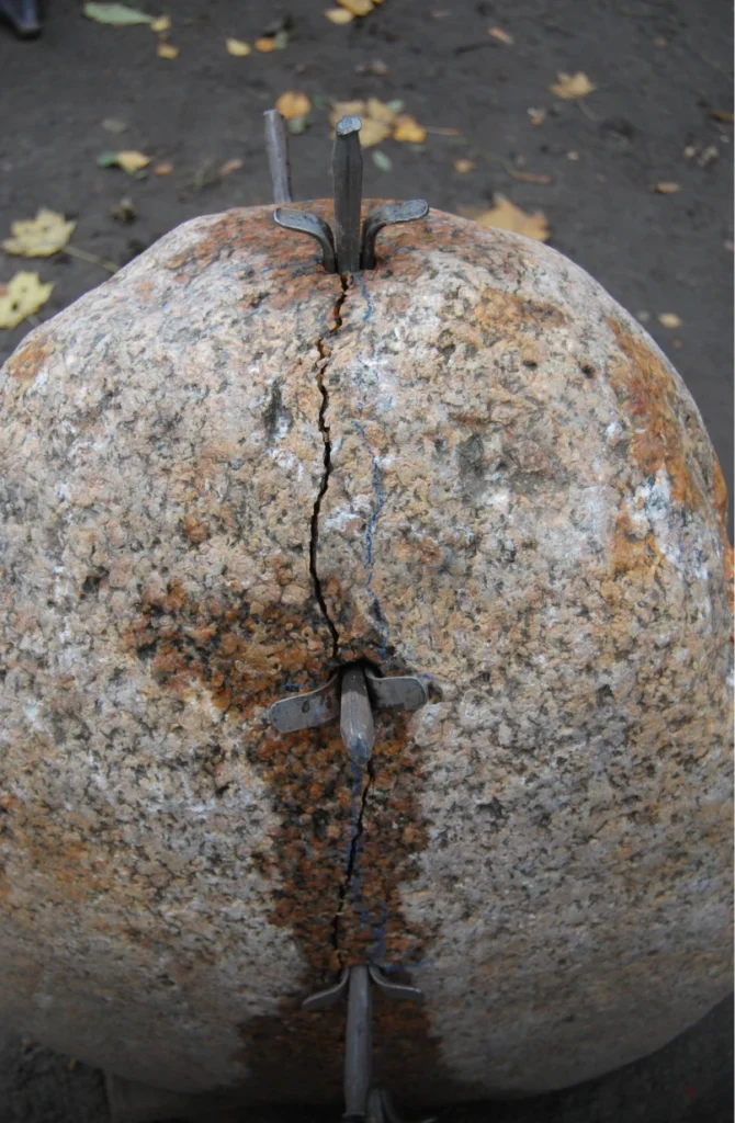 Grabstein aus Stein, der sichtbar in zwei Teile gebrochen ist