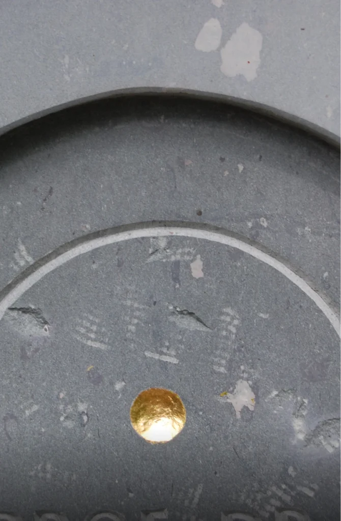 Nahaufnahme eines Grabsteins mit feinen Strukturen und Materialdetails