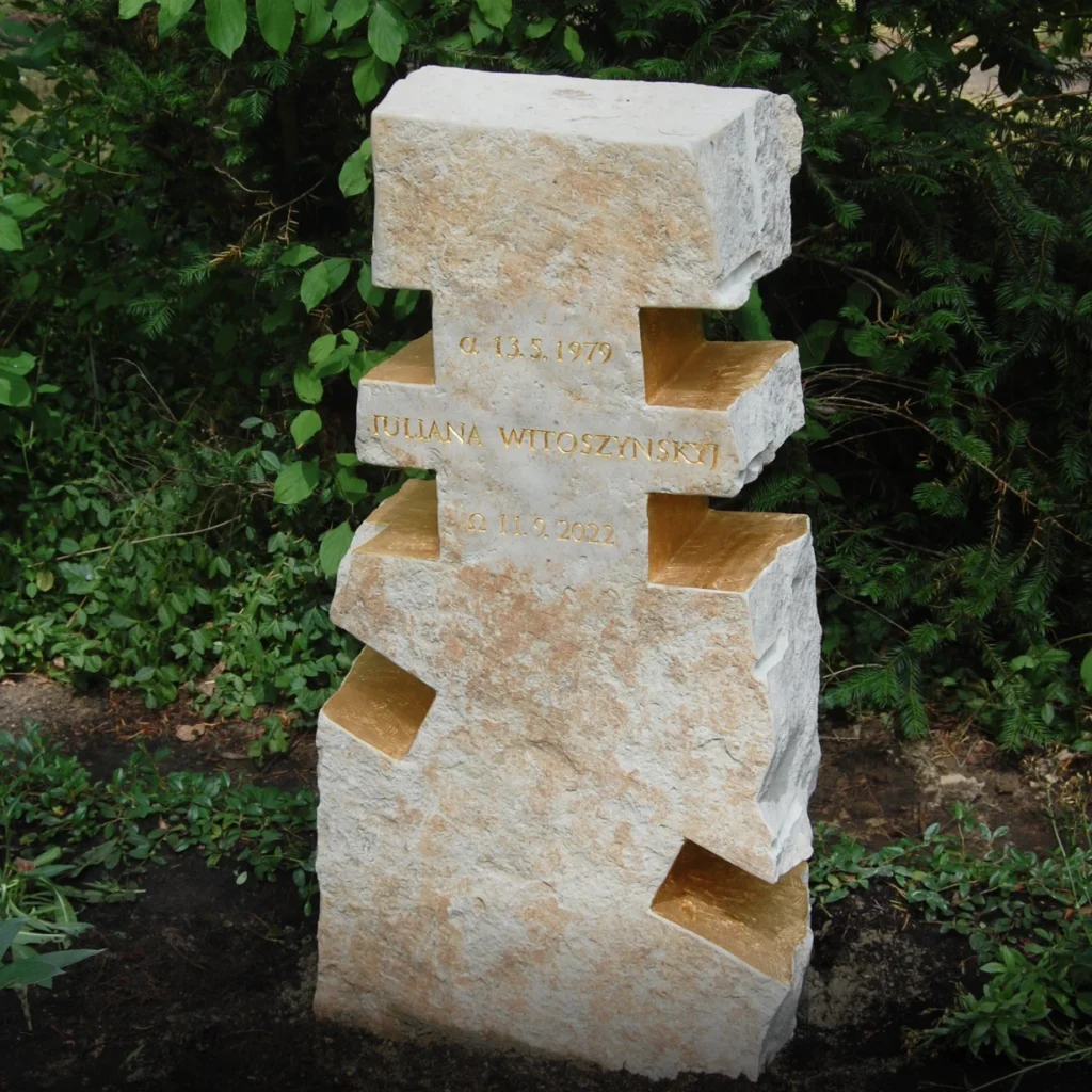 Kalkstein-Grabmal mit negativ herausgearbeitetem Kreuz und vergoldeten Innenflächen