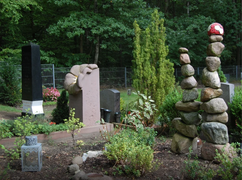 Grabmal zwischen anderen Grabsteinen auf einem Friedhof