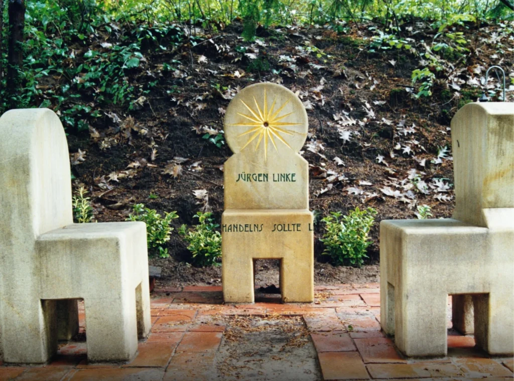 Drei stuhlähnliche Grabmale aus Sandstein im Kreis angeordnet – Denkwerk Jürgen Linke