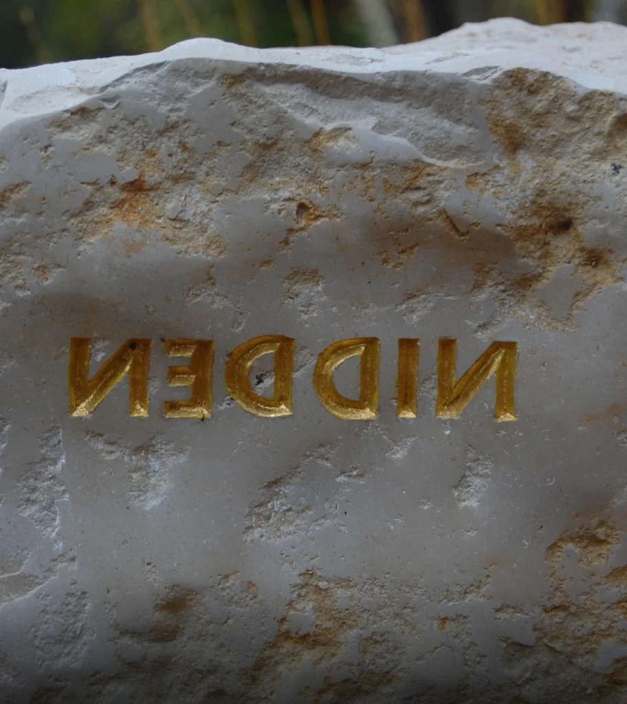 Rückseite eines Grabsteins mit eingearbeitetem Schriftzug „Nidden“ in Spiegelschrift