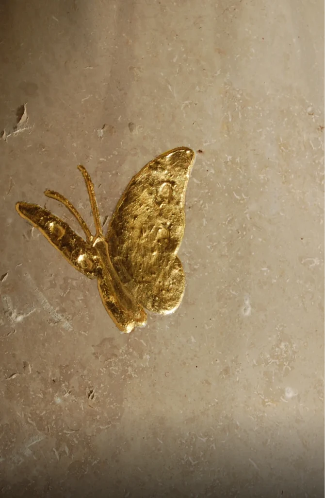 Detail eines Schmetterlingsmotivs auf einem Grabstein