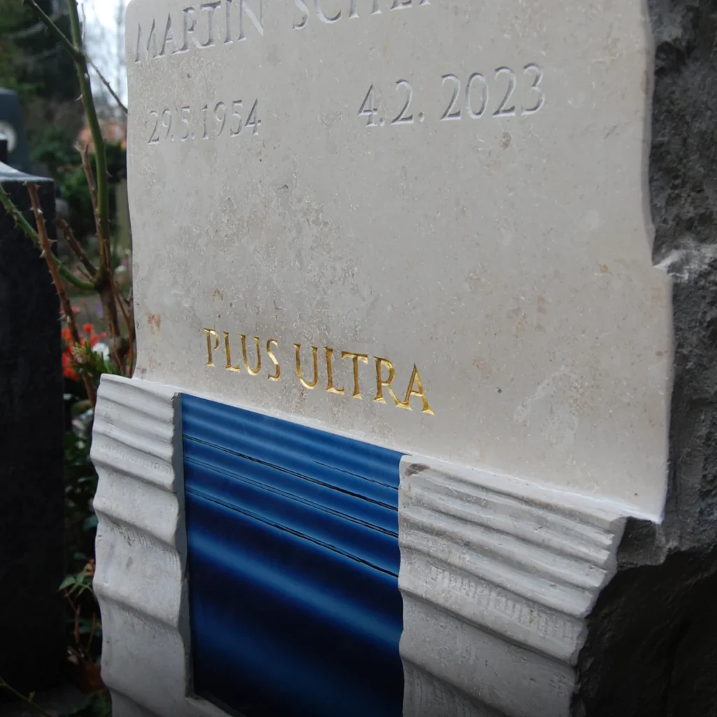 Seitliche Ansicht eines Grabsteins aus Kalkstein mit eingelassenem Meeresfoto und strukturierter Oberfläche