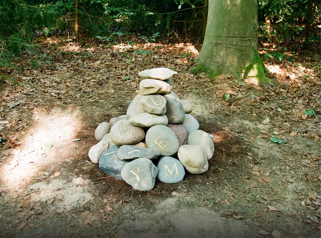 Aufeinandergeschichtete Findlinge mit eingravierten Buchstaben und Zahlen – Grabmal für Ruven Ray