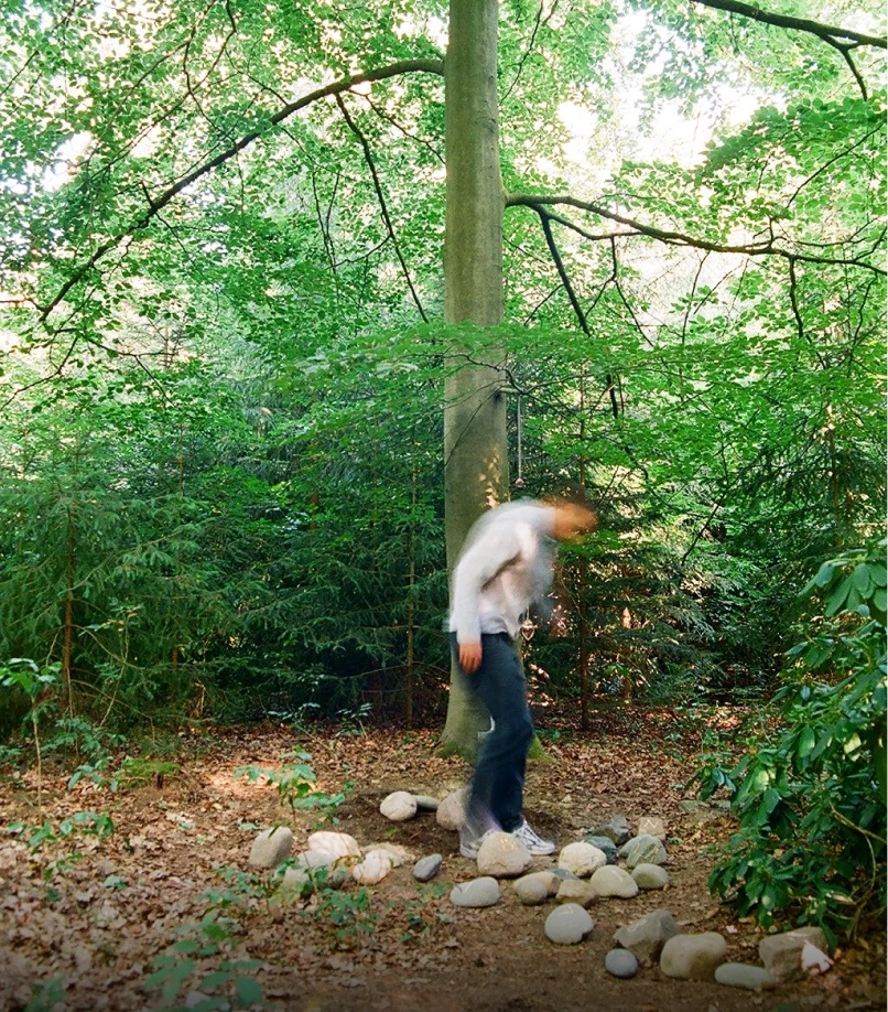 Person beginnt beschriftete Findlinge zu einem Stapel anzuordnen