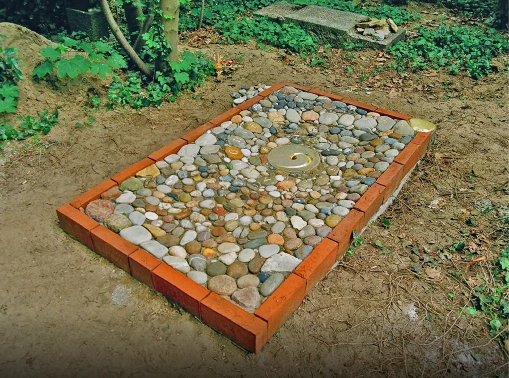Grabstelle mit Bodenrelief aus vielen Steinen und spiralförmiger Gestaltung – Denkwerk Stefan Lühle