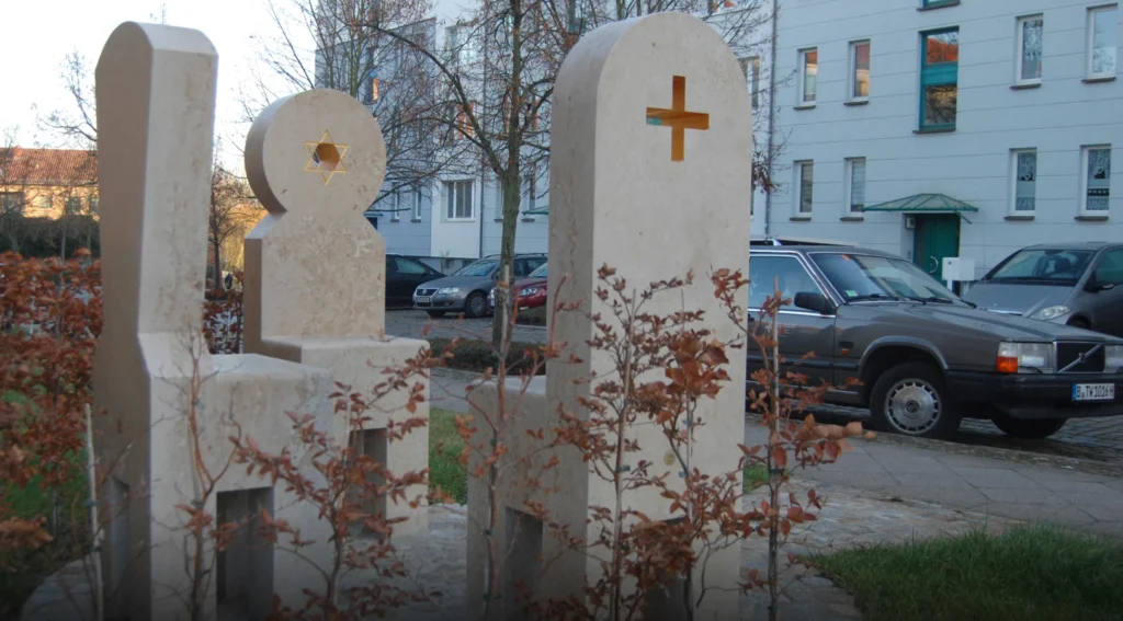 Drei Stühle als Kunstprojekt „Drei Stühle für Malchin“ von Michael Spengler mit Häusern im Hintergrund