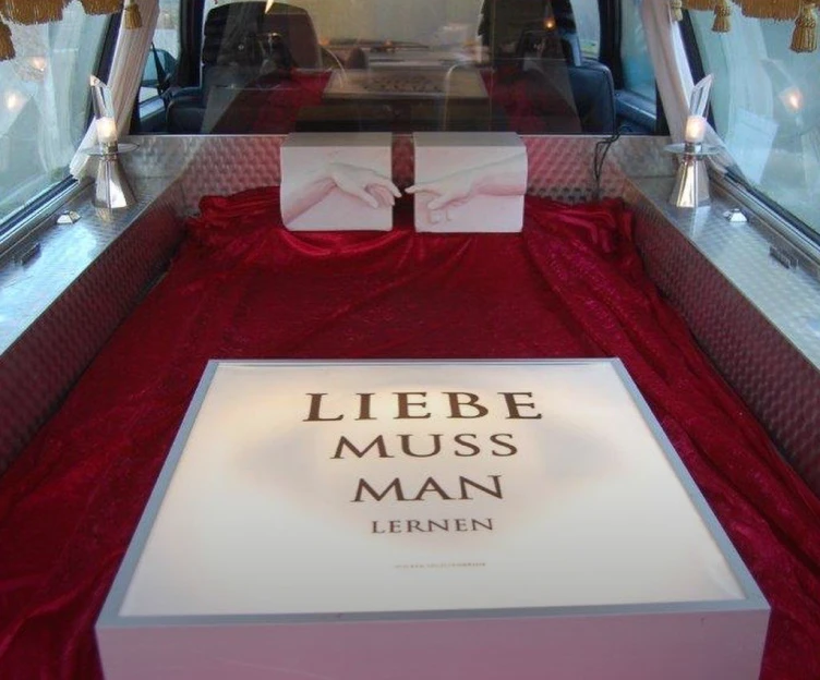 Innenansicht des umgebauten Volvo Bestattungswagens mit der Ausstellung „Liebe muss man lernen“ in der Galerie im Schneewittchensarg