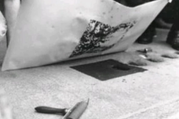 Befeuchtetes Papier wird mit einer Rolle auf einen eingefärbten Pflasterstein gedrückt beim Kunstprojekt „ge(h)steine – topolithografia“ von Michael Spengler