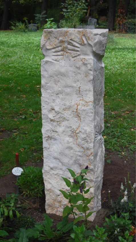 Grabstein aus Kalkstein mit eingearbeiteten Abdrücken von Händen und Armen