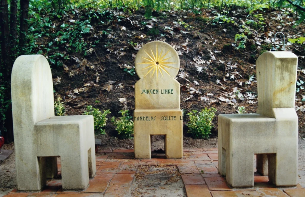 Sandstein-Stuhl mit Inschrift „Leitschnur Eures Handelns sollte Lebensfreude sein“ – Grabmal Jürgen Linke