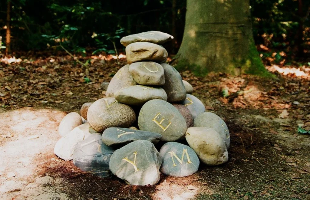 Aufeinandergeschichtete Findlinge mit eingravierten Buchstaben und Zahlen – Grabmal für Ruven Ray