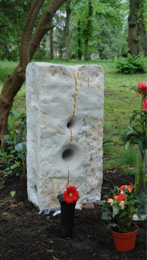 Aufgestellter Grabstein aus Kalkstein mit vergoldetem Riss in natürlicher Umgebung
