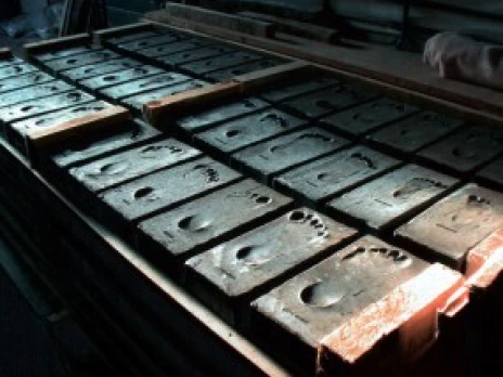 Teaserbild zum Kunstprojekt „Lebenswege“ von Michael Spengler, Kinder betrachten Ziegelsteine mit Fußabdrücken