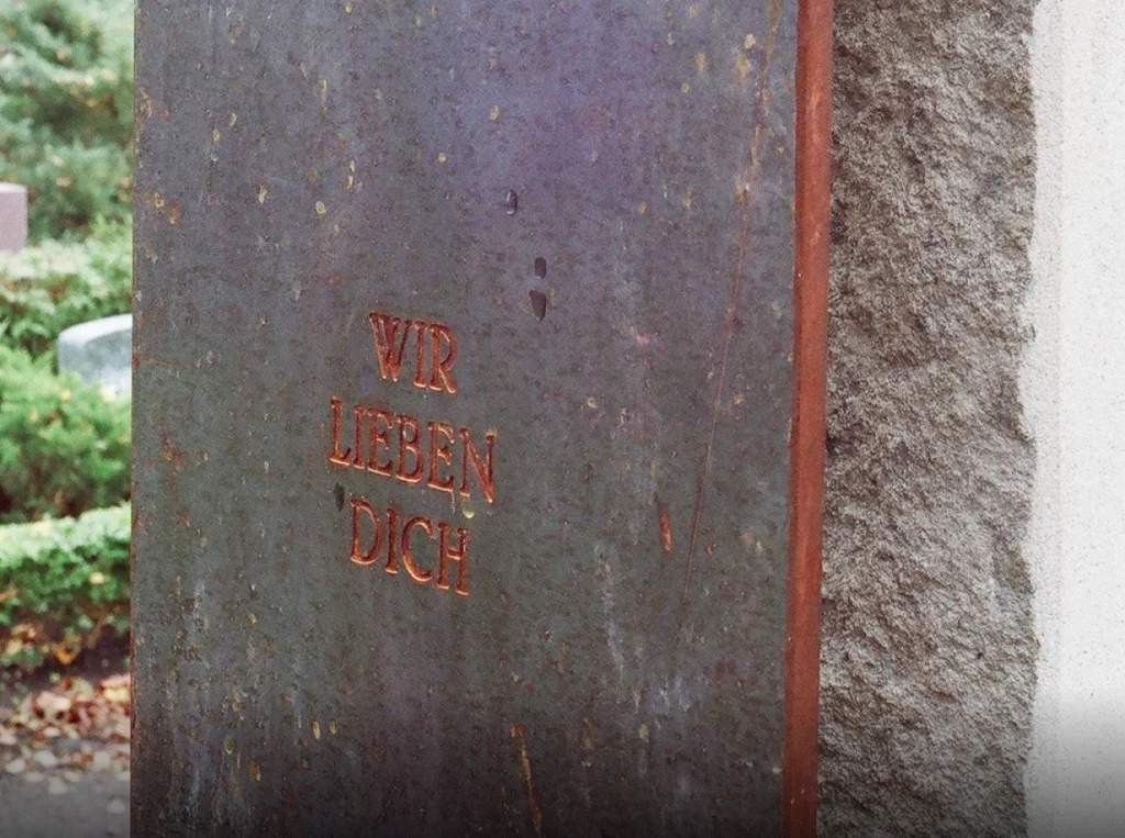 Detail mit der Inschrift Wir lieben Dich auf Cortenstahl