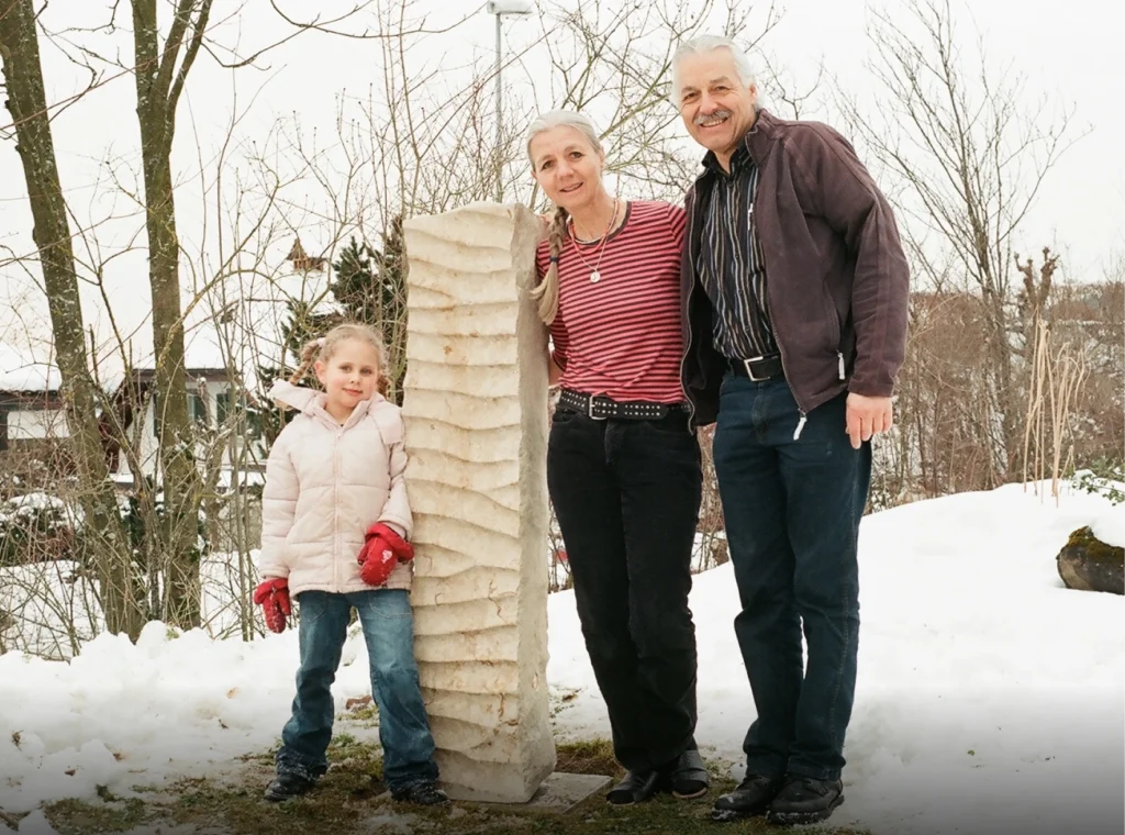 Denkwerk für Elisabeth und Thomas Camenzind im Garten mit Angehörigen – Stele aus Jura Kalkstein