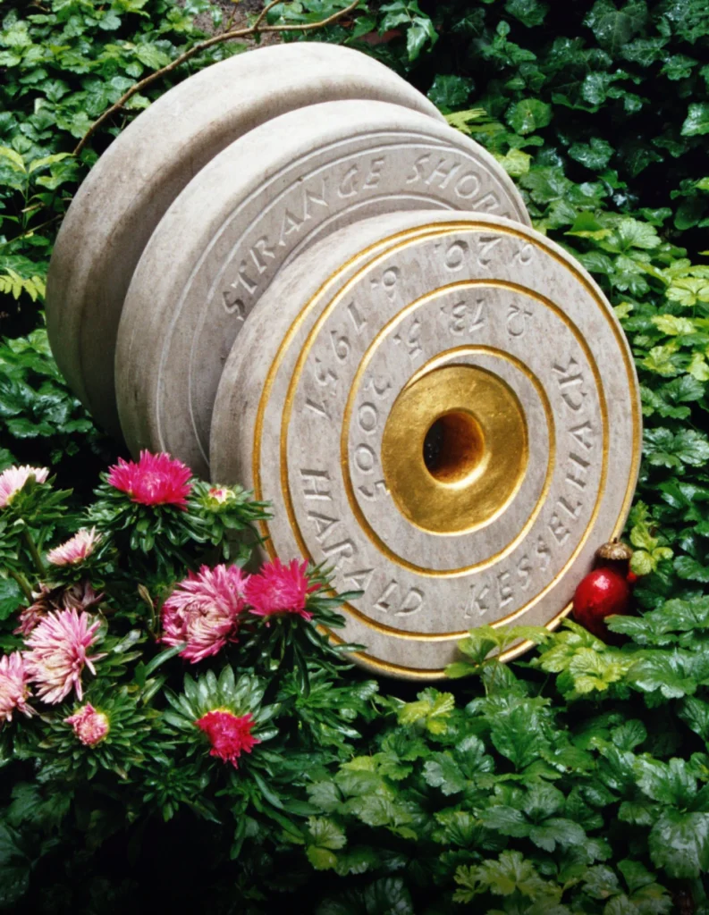 Grabmal mit drei runden, schallplattenähnlichen Steinelementen mit spiralförmigen Rillen