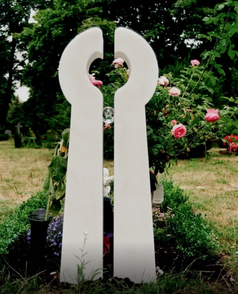 Marmorgrabmal in Form von zwei Händen mit Glaskugel und Schmetterling