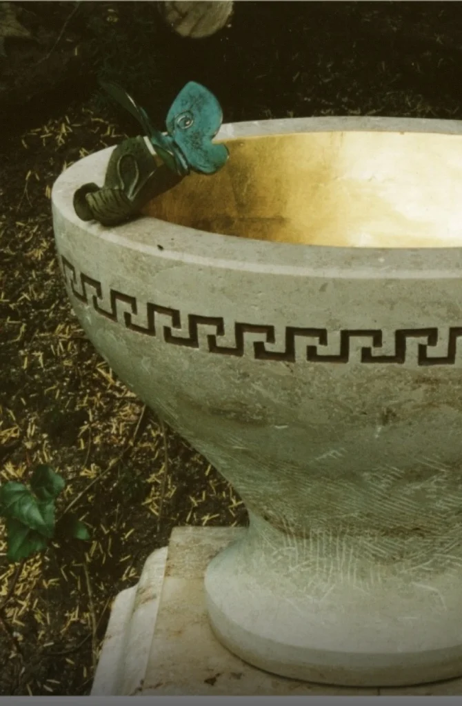 Detail eines Grabsteins mit Messingklammer in Form eines Schmetterlings