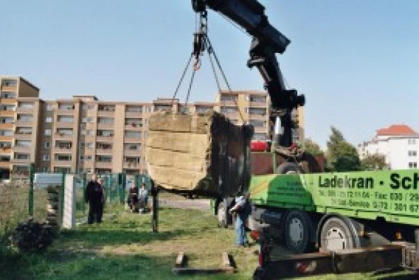 Schwerlasttransporter lädt Sandsteinblock auf dem Gelände der Kapelle der Versöhnung in Berlin ab