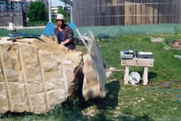 Obere Ecken eines Sandsteinblocks werden mit Keilen abgetrennt
