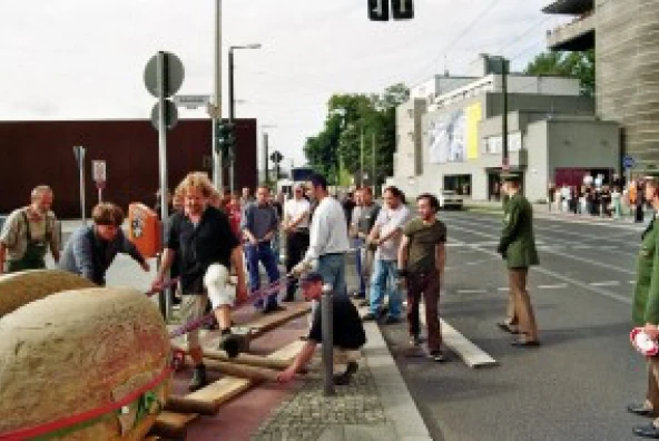 Große Sandstein-Schrippe wird nach Pause unter Polizeibegleitung über die Bernauer Straße bewegt