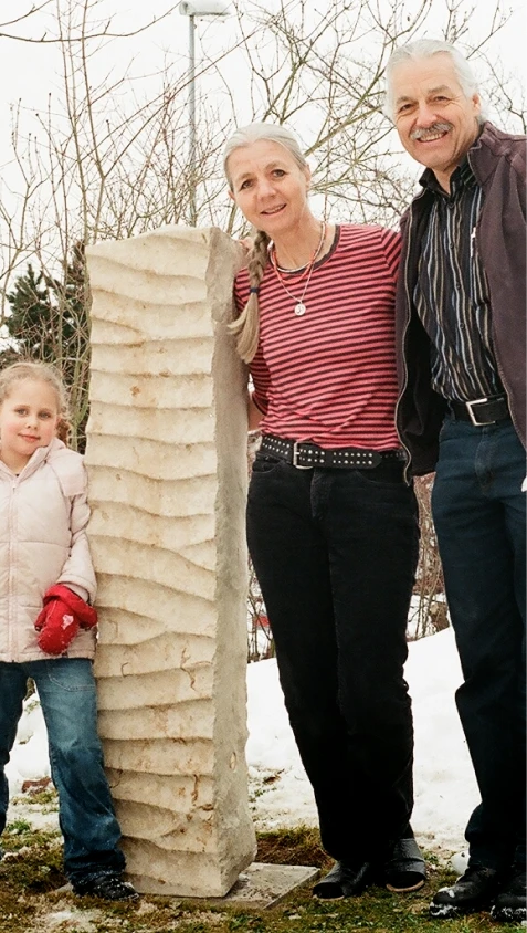 Denkwerk für Elisabeth und Thomas Camenzind im Garten mit Angehörigen – Stele aus Jura Kalkstein