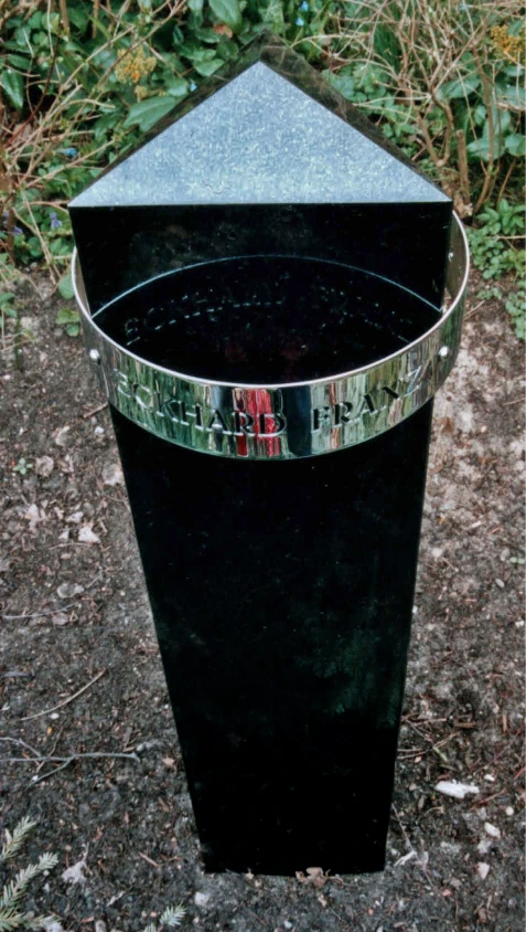 Schwarzer Granitgrabstein mit dreieckigem Querschnitt und pyramidenförmigem Abschluss