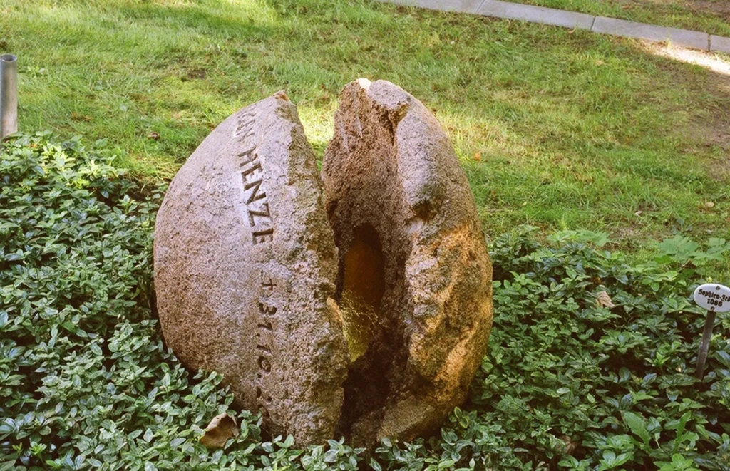 Gespaltener Findling mit geöffneten Hälften und vergoldetem Inneren – Grabmal für Jürgen Henze