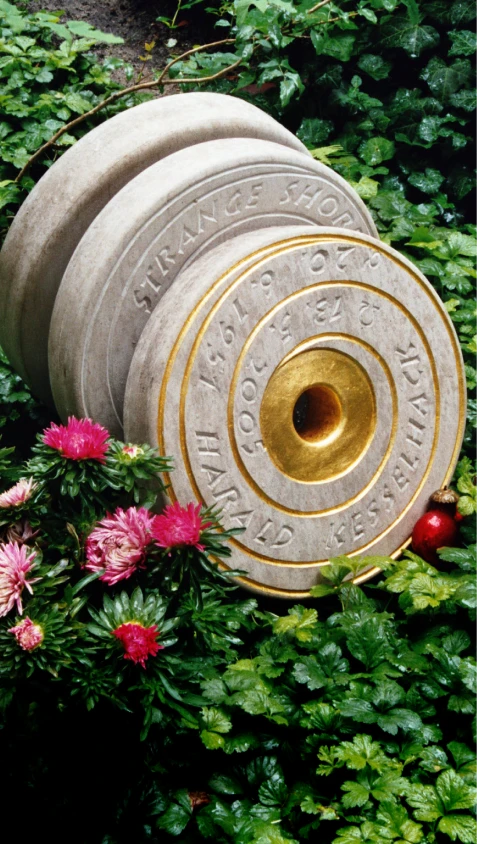 Grabmal mit drei runden, schallplattenähnlichen Steinelementen mit spiralförmigen Rillen