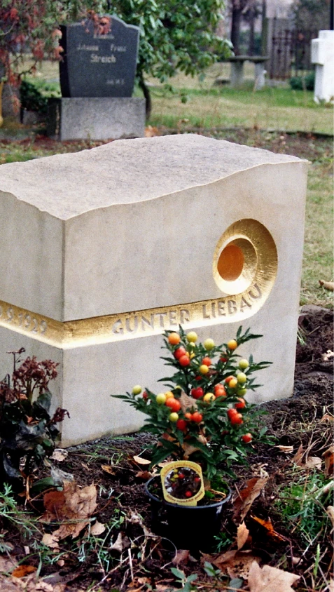 Flach liegender Sandstein mit spiralförmigem, vergoldetem Durchbruch – Grabmal für Günter Liebau