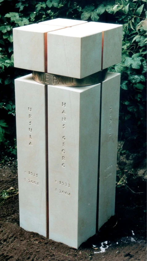 Vier Sandstein-Stelen, verbunden durch einen Ring aus Messing – Grabmal Familie Paul