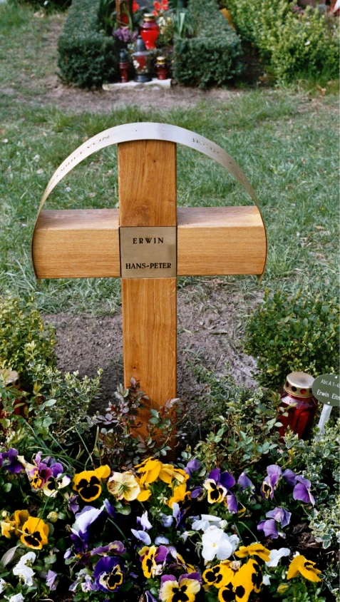 Grabstein mit Kreuz und schützendem Messingbogen mit Inschrift